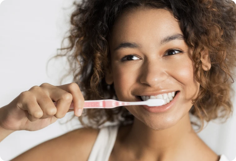 Jeune femme souriante se brossant les dents