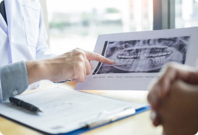 Dentiste analysant une radiographie du maxillaire pour évaluer l'atrophie osseuse